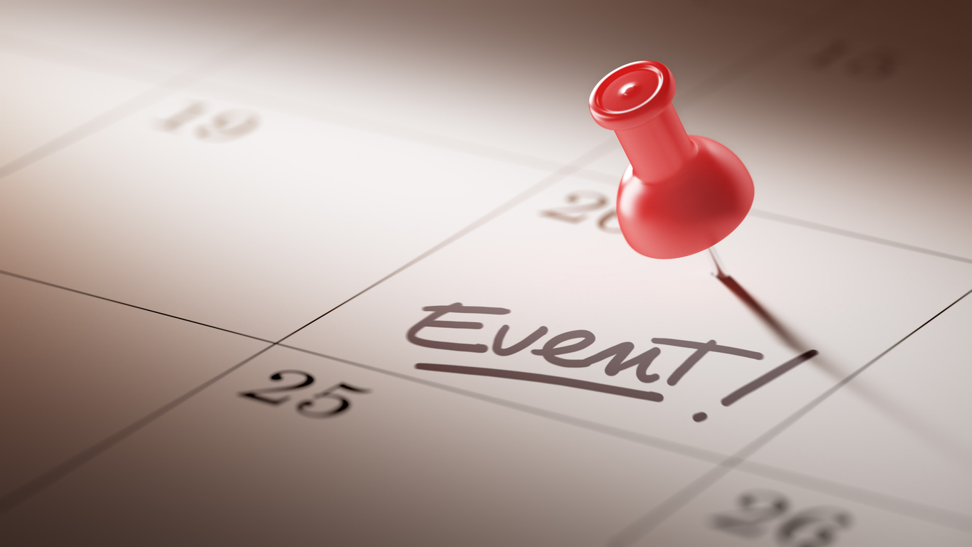 A calendar with a red push pin marking the date of an upcoming corporate event.